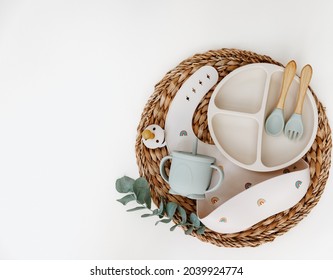 Flat Lay Baby Food Accessories. Silicone Bib, Fork And Spoon On Light Background. 