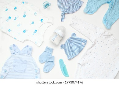 Flaches Set von Babybekleidung und Accessoires in blauer Farbe auf weißem Hintergrund.