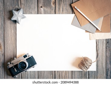Flat lay background with retro camera and letters on wooden surface.