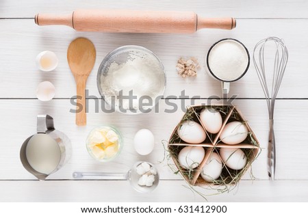 Flat lay Baking background. Top view of cooking ingredients and utencils for yeast dough and pastry on white rustic wood