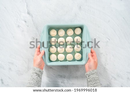 Flat lay. Baking dinner rolls from the premade frozen dough in the baking pan.