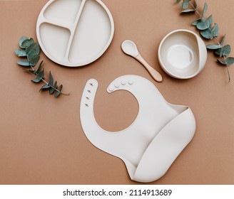 Flat lay beige silicone dishware for baby. Serving kid first feeding concept. copy space, top view - Shutterstock ID 2114913689
