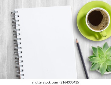 Flat lay blank notebook, offee,glasses and other office equipment on white office desk. Top view with copy space.
