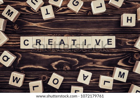 flat lay with blocks arranged in creative word on brown wooden surface