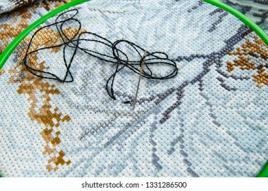 Flat lay canvas with a beautiful pattern of bright sewing threads and a needle for embroidery close-up