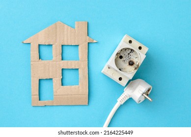 Flat Lay Of Cardboard House And Burnt Electrical Appliances Of Home Power Grid, Wire Plug And Din Socket