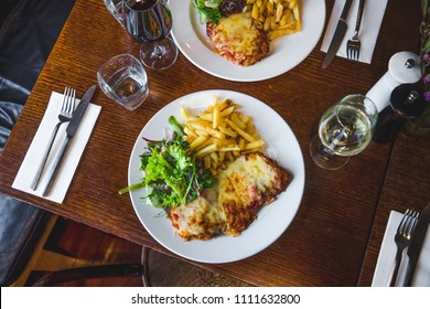 Flat Lay Chicken Parmigiana With Chips And Salad