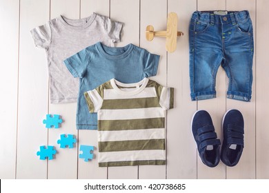 Flat Lay Children Clothing And Accessories On Wooden Background