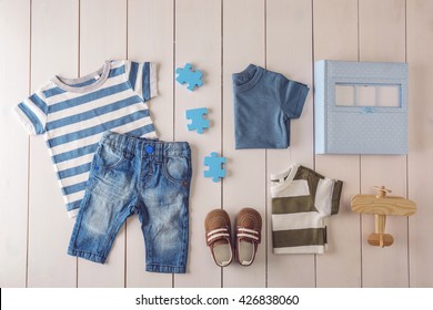 Flat Lay Children Clothing And Accessories On Wooden Background