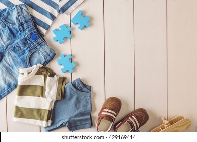 Flat Lay Children Clothing And Accessories On Wooden Background