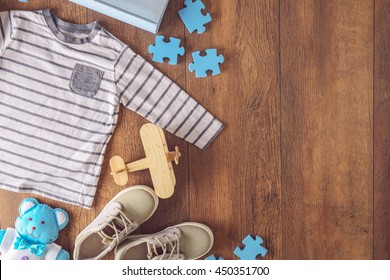 Flat Lay Children Clothing And Accessories On Wooden Background