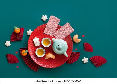 Flat Lay Chinese New Year Tea Set And Snack On Green Background Still Life.