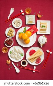 Flat Lay Chinese New Year Food And Drink, Reunion Dinner Food Still Life On Red Table Top Background. Translations Of Text Appear In Image: Prosperity.