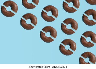 Flat lay chocolate glazed donuts pattern against pastel blue background. Top view. 