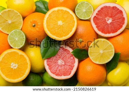 Flat lay of citrus fruits like lime, orange and lemon with lemon tree leaves on light colored background. Space for text healthy concept. Top view.