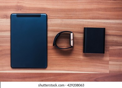 Flat lay of clever new technology of today - portable charger powerbank, smart wrist watch, tablet pc. Travel and connect to work and have fun from anywhere you want
