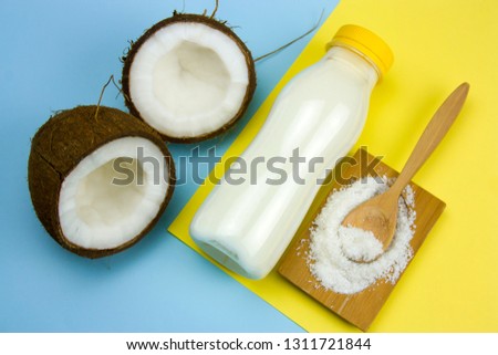 flat lay coconut,cocnut flakes  and cocnut milk  bottle on a yellow and blue background