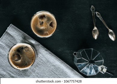 Flat Lay With Coffee Maker, Glasses Of Cold Iced Coffee And Spoons On Black Tabletop