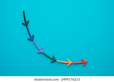 Flat lay colorful arrow sign symbol falling down on blue background copy space. Abstract economy crisis, stock market collapse, business, finance and investment loss concept. - Powered by Shutterstock