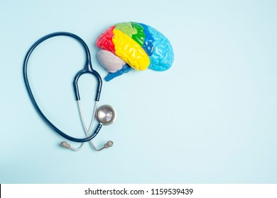 Flat lay colorful brain, heart and stethoscope - blue background.
