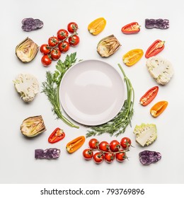 Flat Lay Of Colorful Salad Vegetables Ingredients Around Empty Plate With Seasoning On White Background, Top View.  Healthy Clean Eating Layout, Vegetarian Food And Diet Nutrition Concept