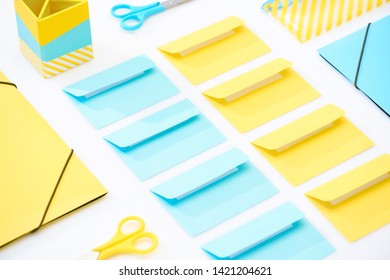 flat lay of colourful envelopes, scissors, folders, pencil case and pencil box on white background - Shutterstock ID 1421204621