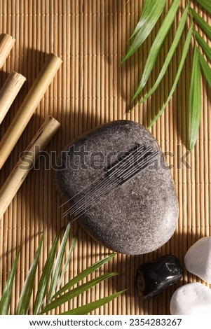 Flat lay composition with acupuncture needles on bamboo mat