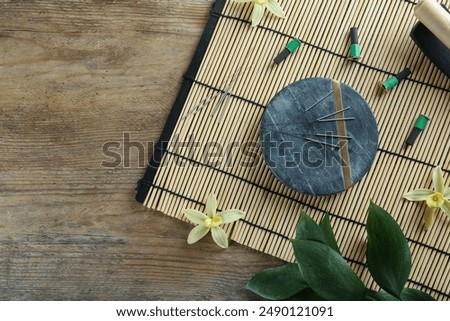 Flat lay composition with acupuncture needles on wooden table. Space for text