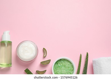 Flat lay composition with aloe vera and cosmetic products on pink background. Space for text
