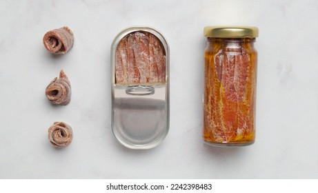 Flat lay composition with anchovy fillets on light table