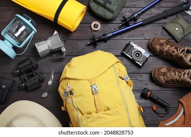 Flat lay composition with backpack and other camping equipment for tourism on wooden background - Shutterstock ID 2048828753
