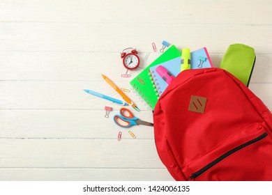 Flat lay composition with backpack and school supplies on white wooden background - Shutterstock ID 1424006135
