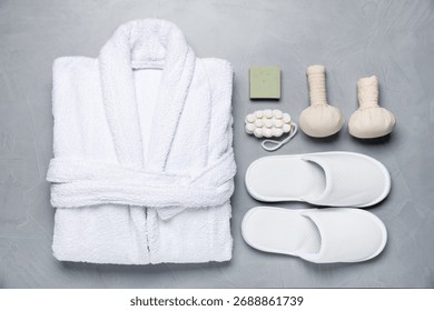Flat lay composition with bathrobe and spa essentials on light grey background