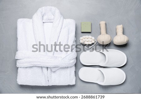 Flat lay composition with bathrobe and spa essentials on light grey background