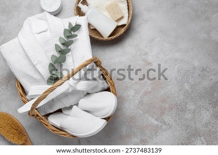 Flat lay composition with bathrobe and spa essentials on light grey background. Space for text