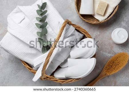 Flat lay composition with bathrobe and spa essentials on light grey background