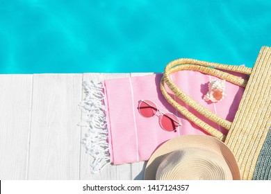 Flat Lay Composition With Beach Accessories On Wooden Deck Near Swimming Pool. Space For Text