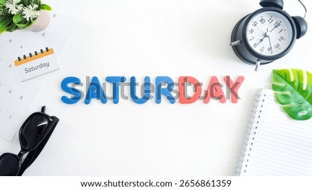 Flat lay composition with blue and red color foam letters spelling word SATURDAY isolated on white background
