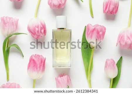 Flat lay composition with bottle of aromatic perfume and beautiful tulips on white background