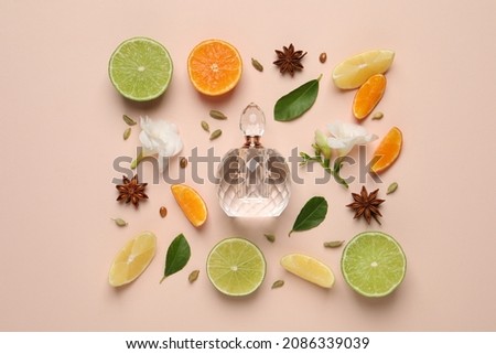 Flat lay composition with bottle of perfume, citrus fruits and flowers on pink background