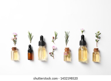 Flat Lay Composition With Bottles Of Natural Tea Tree Oil On White Background