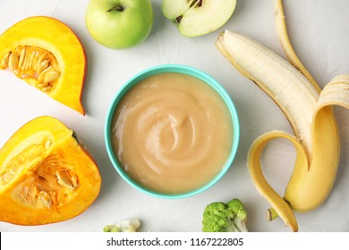 Flat Lay Composition With Bowl Of Healthy Baby Food On Gray Background