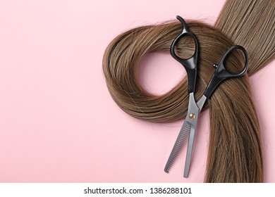 Flat Lay Composition With Brown Hair, Thinning Scissors And Space For Text On Color Background. Hairdresser Service