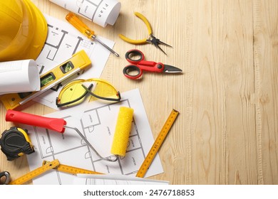 Flat lay composition with building level and other different construction tools on wooden background, space for text