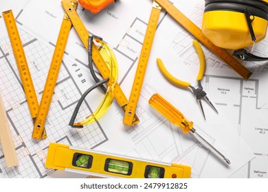 Flat lay composition with building level and other different construction tools on papers