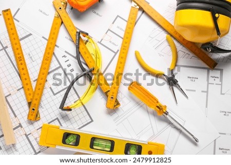 Flat lay composition with building level and other different construction tools on papers