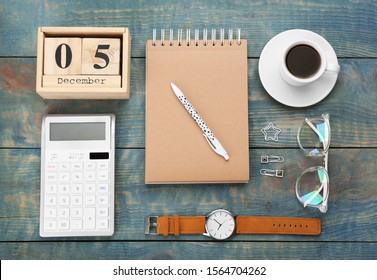 Flat lay composition with calendar and cup of coffee on light blue wooden table