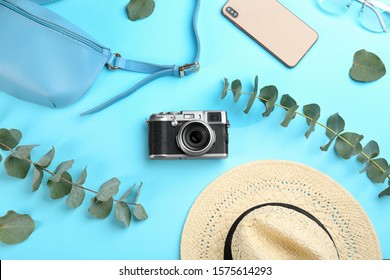 Flat lay composition with camera for professional photographer on light blue background