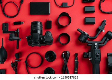 Flat Lay Composition With Camera And Video Production Equipment On Red Background