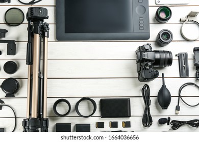 Flat lay composition with camera and video production equipment on white wooden table. Space for text